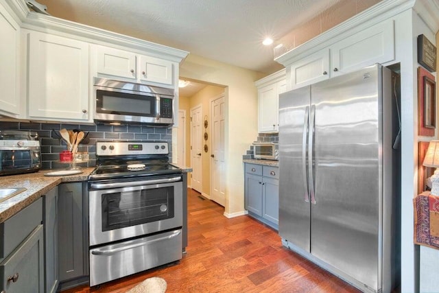 kitchen featuring white cabinetry, stainless steel appliances, and dark hardwood / wood-style floors