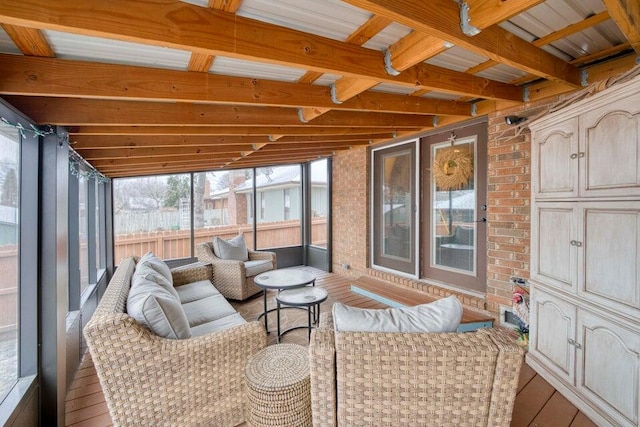 sunroom featuring vaulted ceiling with beams