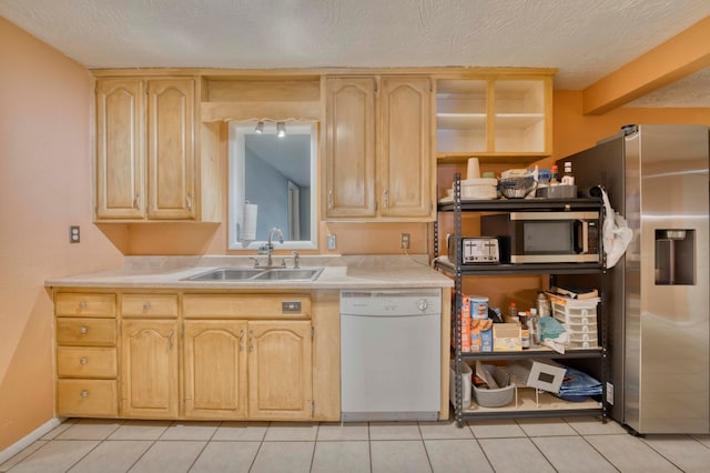 kitchen with appliances with stainless steel finishes, light brown cabinets, and sink