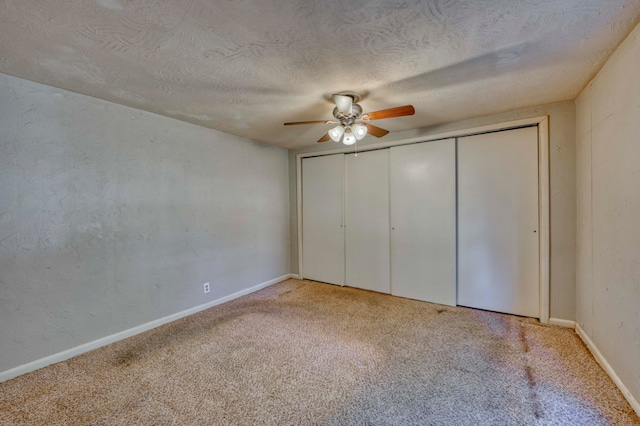 unfurnished bedroom featuring light carpet, a textured ceiling, and ceiling fan