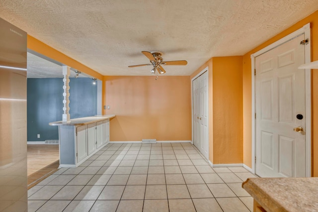 interior space featuring white cabinets, a textured ceiling, light tile patterned floors, and ceiling fan