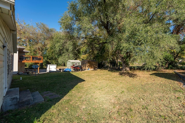 view of yard featuring a deck and a shed