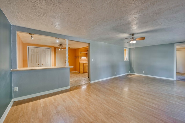 spare room featuring light hardwood / wood-style floors, a textured ceiling, and ceiling fan