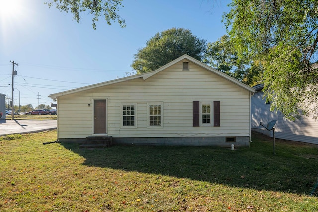 rear view of property featuring a lawn