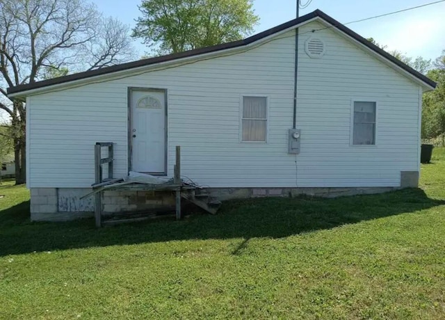 back of property featuring a lawn