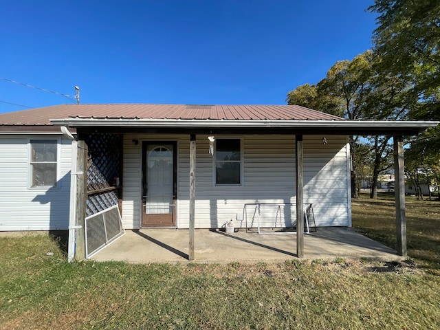 back of house with a patio area and a yard