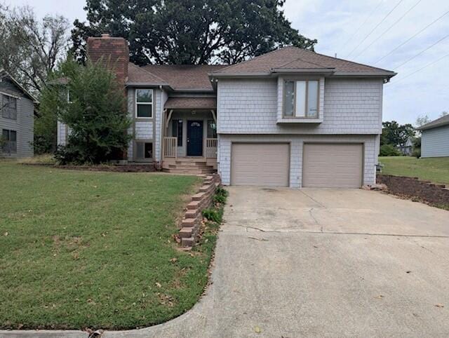 raised ranch with a front yard and a garage