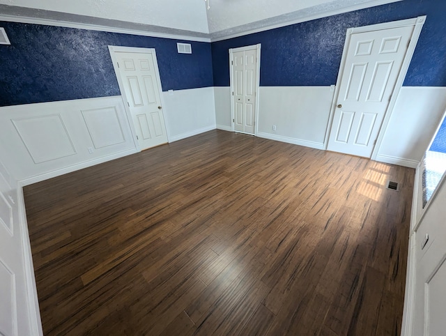 unfurnished room featuring ornamental molding and dark hardwood / wood-style flooring