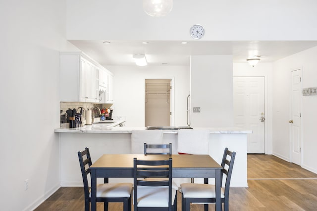 dining room with sink and light wood-type flooring