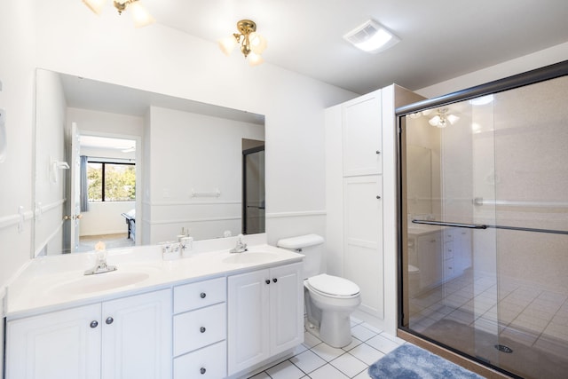 bathroom with vanity, toilet, tile patterned flooring, and a shower with door