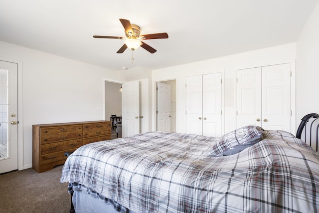 carpeted bedroom with ceiling fan and two closets