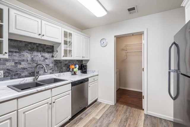 123 River Point Rd Unit 37, Hollister, MO 65672 - kitchen featuring appliances with stainless steel finishes, a sink, tasteful backsplash, and light wood-type flooring