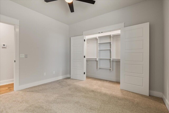 unfurnished bedroom featuring a closet, ceiling fan, and light carpet