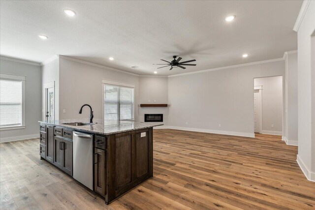 kitchen with sink, light wood-type flooring, dishwasher, ceiling fan, and a center island with sink