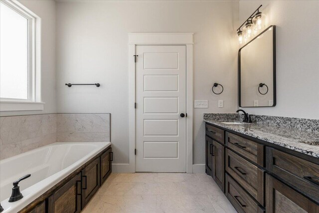 bathroom featuring vanity and a washtub