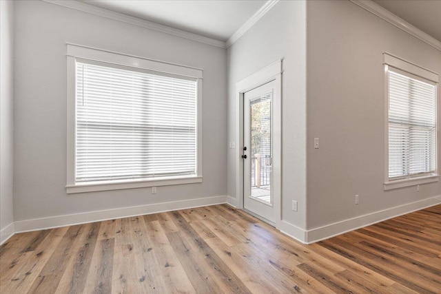 foyer entrance featuring crown molding and light hardwood / wood-style floors