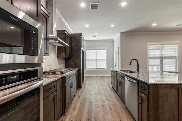 kitchen with light hardwood / wood-style flooring, stainless steel appliances, sink, and crown molding