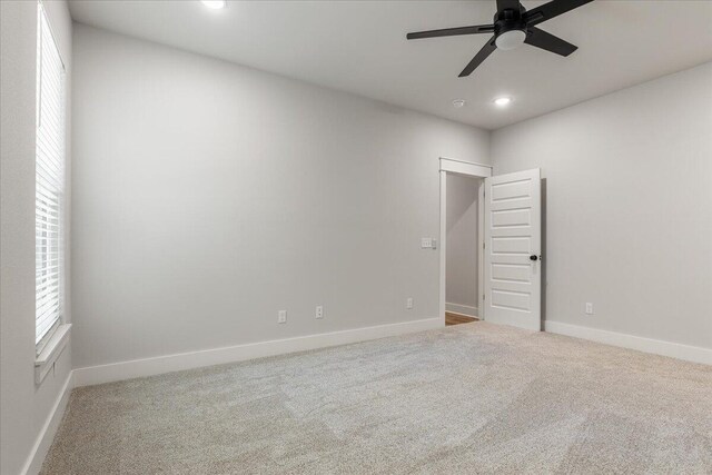 carpeted spare room featuring ceiling fan