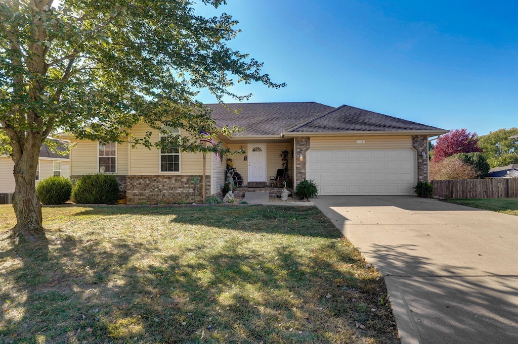 ranch-style house featuring a front yard and a garage