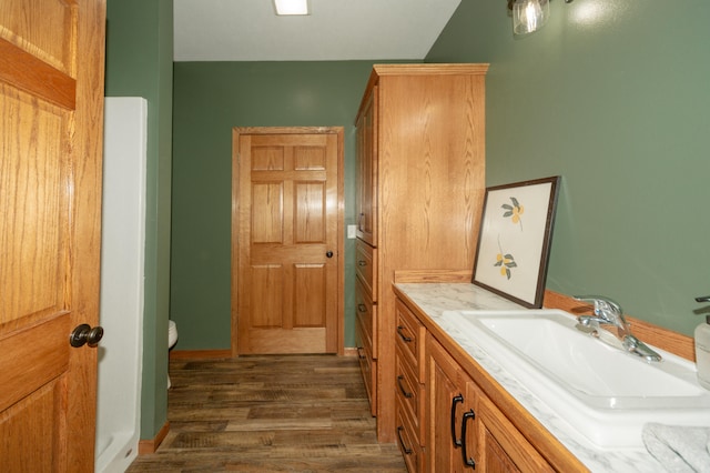 bathroom with vanity, toilet, and hardwood / wood-style floors