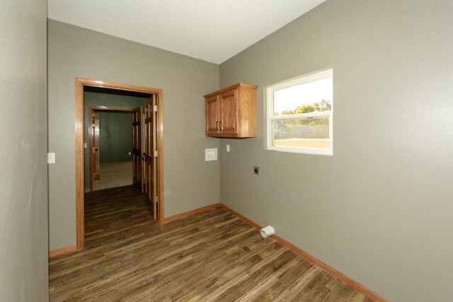 clothes washing area with dark wood-type flooring, electric dryer hookup, and cabinets