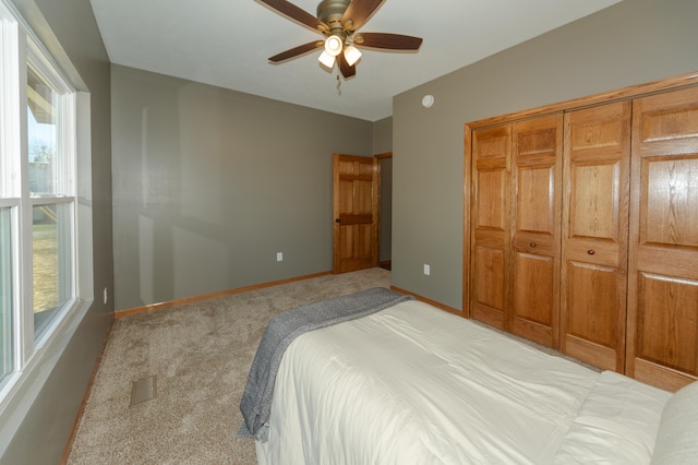 bedroom featuring light carpet, a closet, and ceiling fan