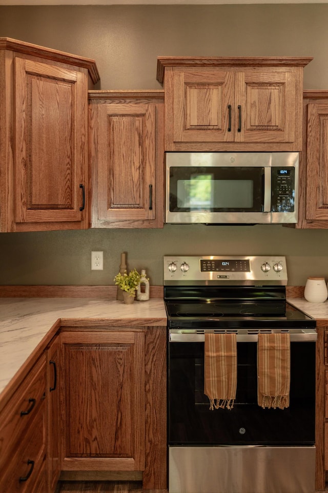 322 W Jefferson St, Bolivar, MO 65613 - kitchen with stainless steel appliances, light countertops, and brown cabinetry