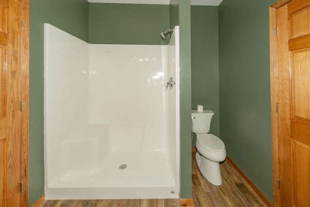 bathroom with wood-type flooring, toilet, and walk in shower