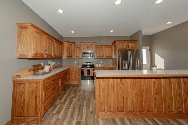 kitchen with sink, stainless steel appliances, and light hardwood / wood-style flooring