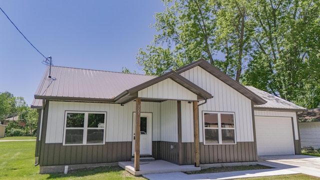 322 W Jefferson St, Bolivar, MO 65613 - view of front of house with an attached garage, a front yard, metal roof, and driveway