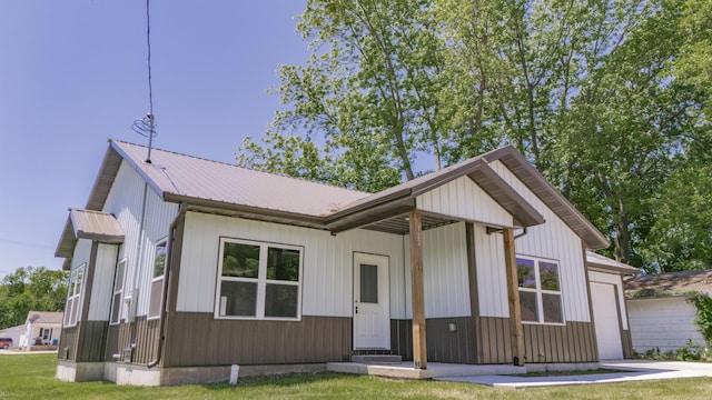 322 W Jefferson St, Bolivar, MO 65613 - modern inspired farmhouse featuring an attached garage, metal roof, a front yard, and driveway