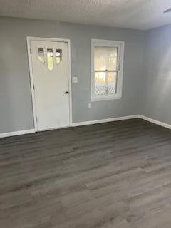 entrance foyer featuring a textured ceiling and dark hardwood / wood-style flooring