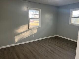 empty room with dark hardwood / wood-style flooring