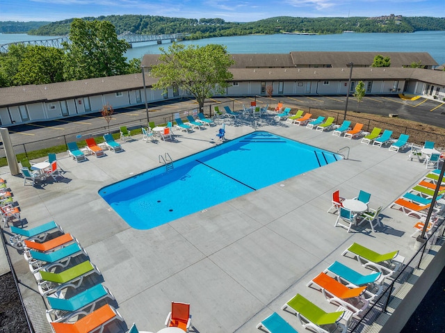 view of swimming pool with a patio and a water view