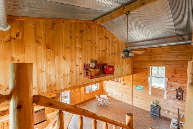 interior space featuring wooden walls and vaulted ceiling with beams