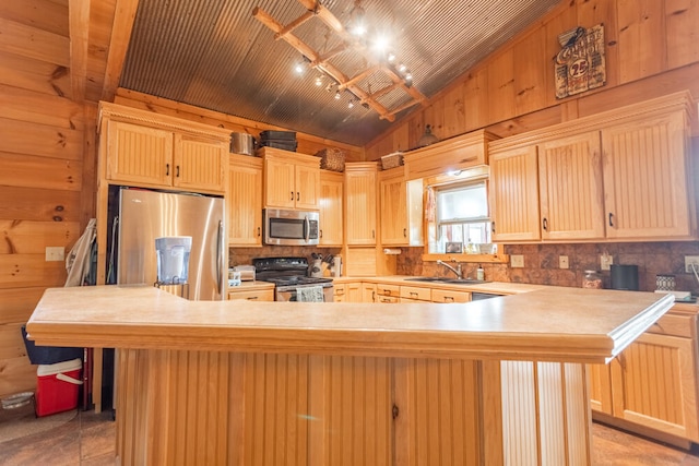 kitchen featuring sink, stainless steel appliances, light brown cabinetry, and lofted ceiling