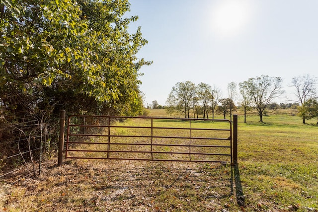 view of gate featuring a rural view and a yard