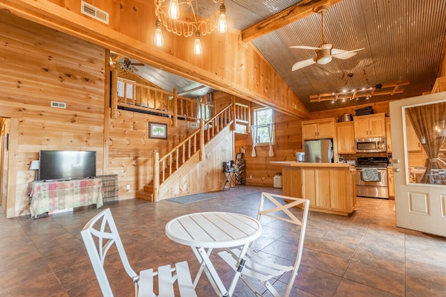 interior space with ceiling fan, high vaulted ceiling, beamed ceiling, and wood walls