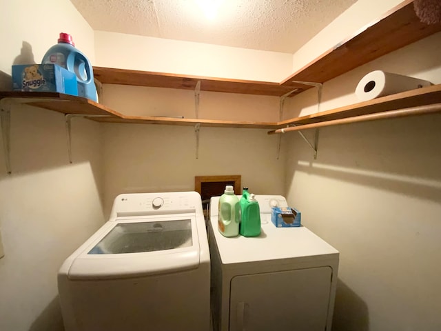 washroom featuring a textured ceiling and washing machine and clothes dryer