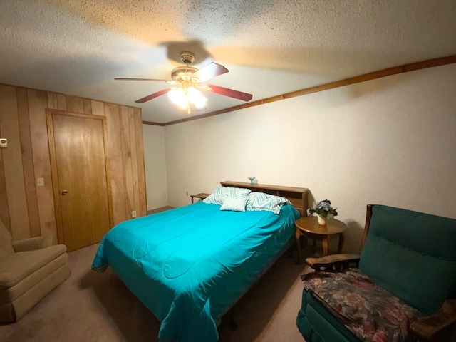 carpeted bedroom with ceiling fan, crown molding, and a textured ceiling