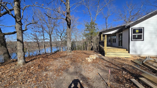 view of yard with a deck with water view