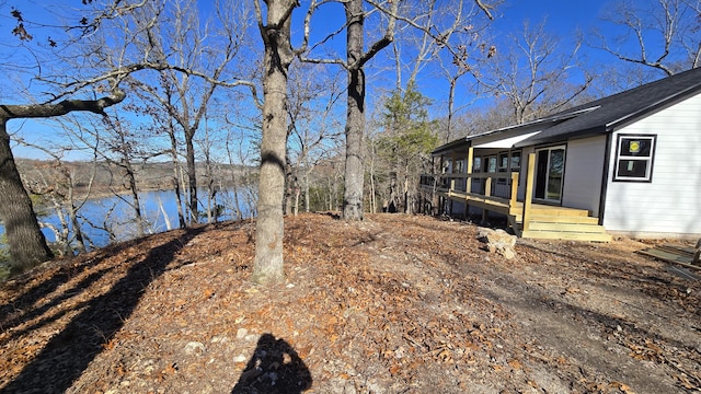 view of yard with a deck with water view