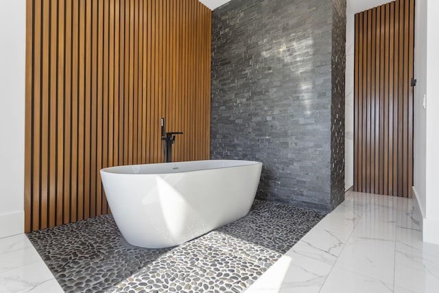 bathroom featuring wooden walls and a bath