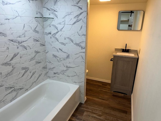 bathroom featuring tiled shower / bath, vanity, and hardwood / wood-style floors