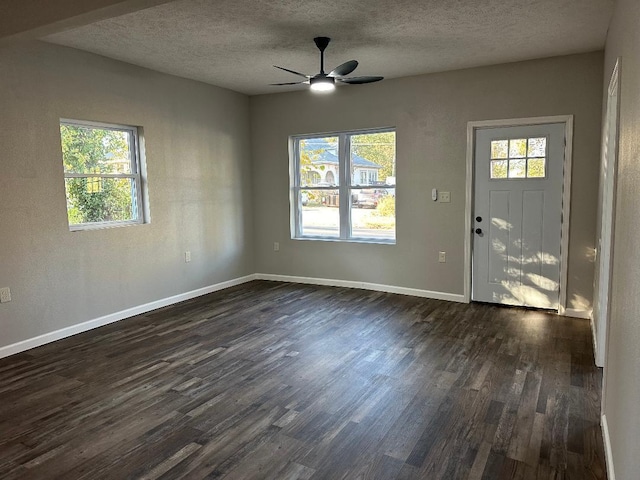 entrance foyer with ceiling fan, a textured ceiling, and dark hardwood / wood-style flooring