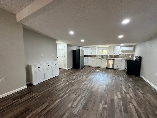 kitchen featuring tasteful backsplash, dark hardwood / wood-style flooring, a textured ceiling, white cabinetry, and stainless steel appliances