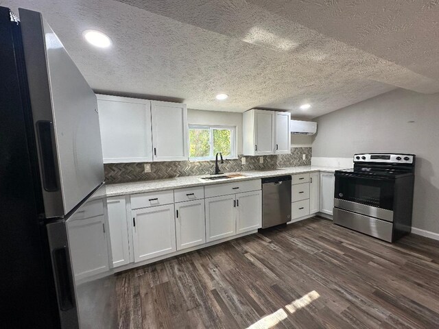 320 W N St, Mountain Grove, MO 65711 - kitchen featuring stainless steel appliances, a sink, a wall mounted AC, dark wood-style flooring, and white cabinets