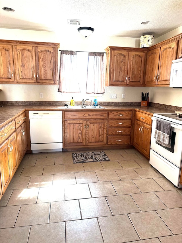 kitchen featuring sink, a textured ceiling, and white appliances