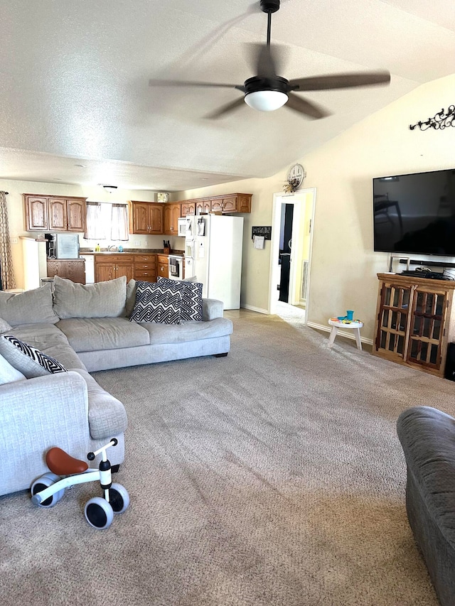 living room with ceiling fan, light carpet, a textured ceiling, and lofted ceiling