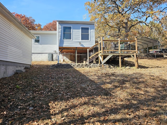 rear view of house featuring cooling unit, a deck, and a carport